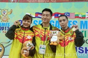 Hai VĐV Wushu Brunei Lee Ying Shi và Faustina Woo Wai Sii cùng HLV sau khi giành HCV.