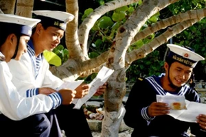 Bộ đội trên đảo Trường Sa lớn đọc thư nhà dưới gốc cây bàng vuông. Ảnh: TRỌNG THIẾT
