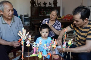 NNƯT Nguyễn Văn Thành (ngoài cùng bên phải) tiếp nối truyền thống gia đình, nỗ lực phát triển nghề nặn tò he (làng Xuân La, Phú Xuyên, Hà Nội).