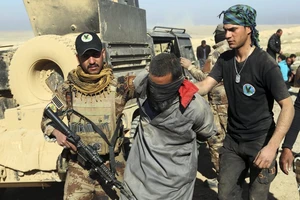 Lực lượng quân sự Iraq bắt giữ một phiến quân IS tại Mosul. (Ảnh: AP)