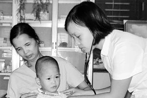 Dù đã phải uống thuốc phơi nhiễm HIV, chị Nguyễn Thị Thái (người ngồi) vẫn gắn bó với các cháu bé có "H" ở Trung tâm bảo