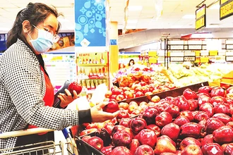 Người tiêu dùng chọn mua trái cây tại một siêu thị Co.opmart ở TP Hồ Chí Minh.