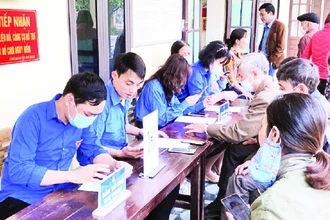 Đoàn viên, thanh niên xã Đồng Phong hướng dẫn người dân cài đặt ứng dụng định danh điện tử (VNeID).
