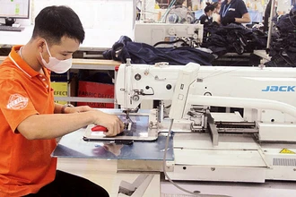 Người lao động ở Thanh Hóa bảo dưỡng thiết bị may công nghiệp.