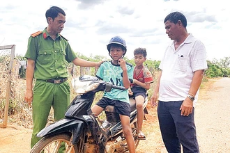 Các thành viên nhóm họ Kpuih (làng Trol Ðeng) phối hợp với Công an thị trấn Chư Ty nhắc nhở các em nhỏ về việc điều khiển xe máy khi chưa đủ tuổi là vi phạm pháp luật. 