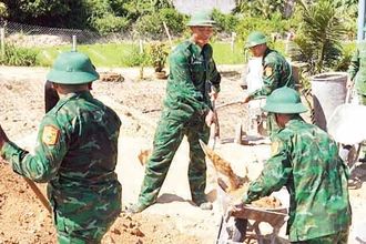 Cán bộ, chiến sĩ Đồn Biên phòng Cát Khánh tham gia xây dựng nhà cho chị Lê Thị Mười ở thôn An Nhuệ, xã Cát Khánh, huyện Phù Cát (Bình Định). 