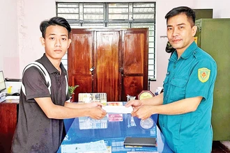 Em Mã Thành Long (trái) nộp đơn tình nguyện nhập ngũ. 