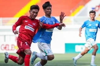 Các cầu thủ đội Trường đại học Tôn Đức Thắng (áo đỏ) trong trận đấu khai mạc chiều nay. (Ảnh: NHẬT THỊNH)