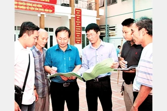 Cán bộ MTTQ phường Yết Kiêu, quận Hà Đông (Hà Nội) trao đổi, giám sát công việc cải tạo một công trình văn hóa. Ảnh: BÁ HOẠT
