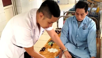 Bác sĩ thăm khám, điều trị phục hồi vết thương, vận động cho bệnh nhân.