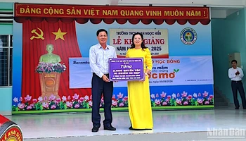 Đại diện chính quyền địa phương và đơn vị trường học tại huyện Đầm Dơi tiếp nhận hỗ trợ xe đạp và tập học sinh được vận động từ Báo Nhân Dân.