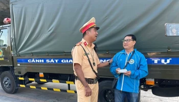 Đại diện Đội Cảnh sát giao thông-trật tự Công an thành phố Thủ Dầu Một trao lại tiền đánh rơi cho ông Nguyễn Thanh Hòa. 