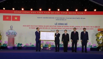 Phó Chủ tịch Quốc hội Trần Quang Phương (bên trái) trao Quyết định thành lập thành phố Bến Cát.