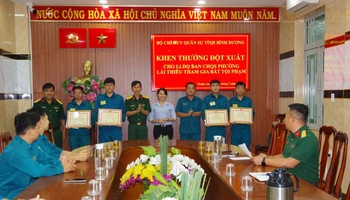 Thượng tá Đặng Xuân Thành trao Giấy khen cho các chiến sĩ dân quân.