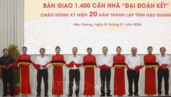 Chủ tịch nước Võ Văn Thưởng cùng các đại biểu thực hiện nghi thức bàn giao 1.400 căn nhà Đại đoàn kết tặng hộ nghèo Hậu Giang. (Ảnh: Thống Nhất/TTXVN)