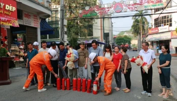 Điện lực thành phố Lào Cai tặng thiết bị chữa cháy cho bà con khu dân cư chợ Cốc Lếu.