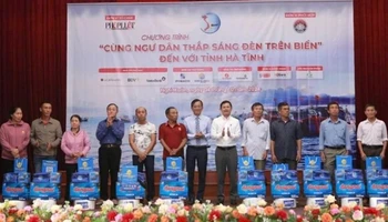 Đại diện lãnh đạo tỉnh Hà Tĩnh và báo Pháp Luật Thành phố Hồ Chí Minh trao quà cho bà con ngư dân. (Ảnh: ĐẶNG TRUNG)