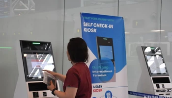 Hành khách quốc tế làm thủ tục tại quầy tự check-in (self-check-in kiosk) chiều ngày 22/4. (Ảnh: ANH ĐÀO)