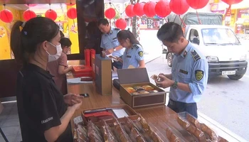 Cán bộ Cục Quản lý thị trường tỉnh Hà Nam kiểm tra nguồn gốc, xuất xứ của các loại bánh trung thu được bày bán trên thị trường.