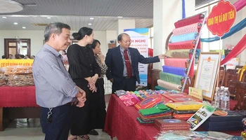 Các đại biểu tham quan gian hàng trưng bày sản phẩm lụa Nha Xá của tỉnh Hà Nam được trưng bày tại hội nghị xúc tiến đầu tư.