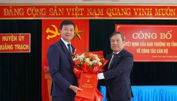 Bí thư Tỉnh ủy Quảng Bình Vũ Đại Thắng trao quyết định, tặng hoa chúc mừng Bí thư Huyện ủy Quảng Trạch Nguyễn Chí Thắng (bên trái).
