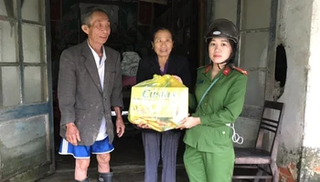 Thượng úy Phan Thị Thủy trao quà cho người dân xã Thạch Hội trong đợt lũ lịch sử năm 2020. (Ảnh: Nhân vật cung cấp)