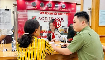 Giao dịch viên Agribank chi nhánh huyện Bắc Sơn và cán bộ đội an ninh, Công an huyện Bắc Sơn, hỗ trợ, tư vấn cho khách hàng suýt bị lừa đảo qua mạng.