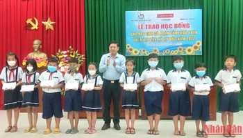 Chủ tịch Hội Nhà báo tỉnh Bến Tre Nguyễn Hữu Thọ trao học bổng cho học sinh nghèo, học giỏi.