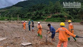 Công nhân Điện lực khu vực Mai Sơn-Yên Châu cùng nhân dân dựng cột tạm, kéo dây cấp điện trở lại cho người dân bản Nhụng Trên.