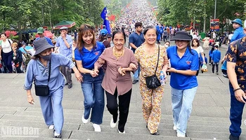 Tình nguyện viên hỗ trợ du khách cao tuổi trên đường lên Đền Hùng. 