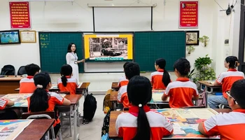 Trình chiếu phụ san đặc biệt của Báo Nhân Dân trong giờ sinh hoạt ngoại khóa tại Trường tiểu học Suối Hoa, thành phố Bắc Ninh.