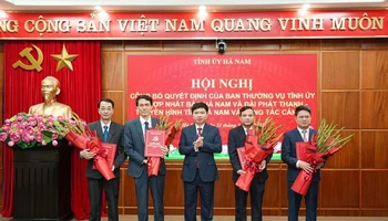 Đồng chí Trương Quốc Huy, Bí thư Tỉnh ủy, Chủ tịch Ủy ban nhân dân tỉnh, Trưởng Đoàn đại biểu Quốc hội tỉnh trao quyết định và tặng hoa chúc mừng Ban Biên tập Báo Hà Nam.