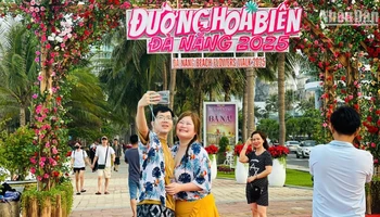 Du khách nước ngoài check-in tại Đường hoa biển Đà Nẵng chiều 30/4. (Ảnh: ANH ĐÀO)
