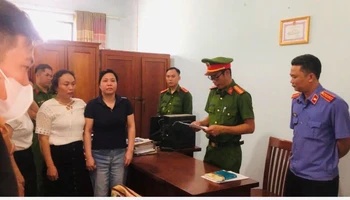 Lực lượng chức năng tống đạt các quyết định khởi tố, lệnh tạm giam đối với bà Lê Thị Hòa. ( Ảnh do công an cung cấp)