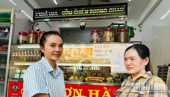 Hộ gia đình chị Phạm Tuyết Linh (bên trái), cơ sở sản xuất bánh mì và chả lụa Sơn Hà nổi tiếng hơn 40 năm qua tại Bạc Liêu ký cam kết với cơ quan chức năng thực hiện nghiêm các biện pháp an toàn thực phẩm trong dịp Tết. (Ảnh: TRỌNG DUY)