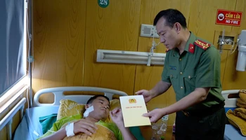 Lãnh đạo Công an tỉnh Yên Bái thăm, động viên thiếu tá Lương Văn Chiến. (Ảnh: THANH SƠN)