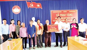 Đại diện Báo Nhân Dân trao bảng tượng trưng số tiền 250 triệu đồng tặng 5 gia đình ở huyện M’Drắk xây nhà Đại đoàn kết.