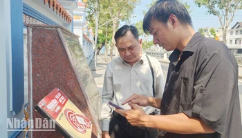 Kỹ sư lắp đặt thiết bị công nghệ hướng dẫn người dân trải nghiệm tại Di tích lịch sử quốc gia Mộ và Đình Nguyễn Trung Trực.