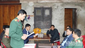 Cán bộ Ban Chỉ huy Quân sự huyện Đức Thọ đọc quyết định xử phạt công dân không thực hiện nghĩa vụ quân sự. (Ảnh: Sang Sơn)