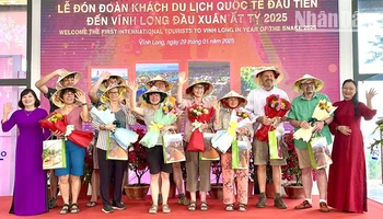 Lãnh đạo tỉnh Vĩnh Long tặng quà và hoa cho khách du lịch quốc tế đầu tiên. 