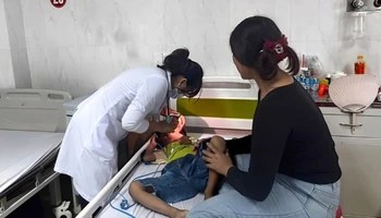 Bác sĩ khoa Nhi tổng hợp, Bệnh viện đa khoa vùng Tây Nguyên thăm khám cho bệnh nhi hóc dị vật đường thở. Ảnh: Quang Nhật.