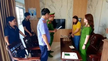 Lực lượng chức năng đọc quyết định tạm giữ hình sự đối tượng Hà Thị Thu Thủy (người mặc áo vàng).