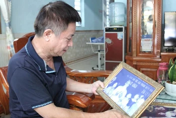 Cựu chiến binh Hồ Quảng Thu bên bức ảnh kỷ niệm chụp cùng Bác.