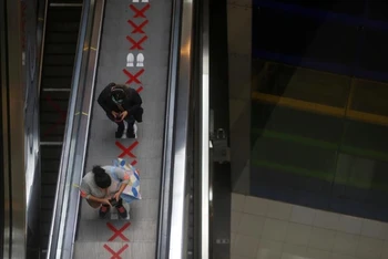 Người dân Peru thực hiện giãn cách xã hội ngay cả khi đi trên thang cuốn tại một trung tâm thương mại ở thủ đô Lima. (Ảnh: Reuters)