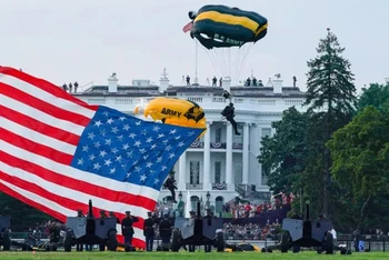 Mang theo quốc kỳ Mỹ, thành viên của đội nhảy dù đáp xuống công viên Ellipse của Nhà trắng trong sự kiện “Chào nước Mỹ” được tổ chức vào ngày 4-7. (Ảnh: Reuters)