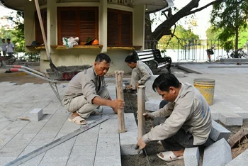 Công nhân lát đá vỉa hè tại khu vực chung quanh hồ Hoàn Kiếm. (Ảnh: THỦY NGUYÊN)
