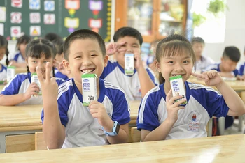 Các em học sinh trường Tiểu học Trang Tấn Khương, xã Long Thới, huyện Nhà Bè vui vẻ đón nhận những hộp sữa an toàn từ chương trình SHĐ.