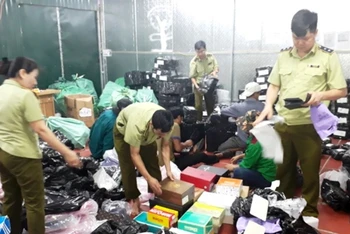 Lực lượng chức năng tiến hành kiểm đếm, phân loại, đóng gói hàng hóa tại kho hàng lậu ở số 145, đường Hoàng Diệu, TP Lào Cai.