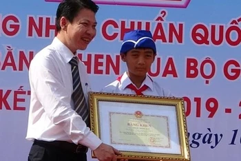 Đại diện Bộ Giáo dục và Đào tạo trao Bằng khen cho em Phạm Trọng Đạt.