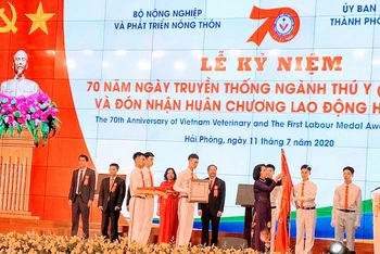 Phó Chủ tịch nước Đặng Thị Ngọc Thịnh gắn Huân chương Lao động hạng Nhất lên cờ truyền thống của ngành thú y Việt Nam.